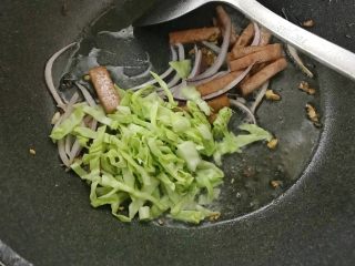 午餐肉时蔬炒乌冬,放入包菜翻炒。