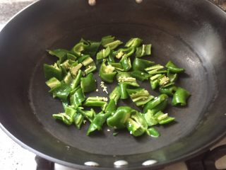 乡味十足➕重庆～烟熏腊肉炒蒜苗,干锅先干煸辣椒，煸至表面微黄。