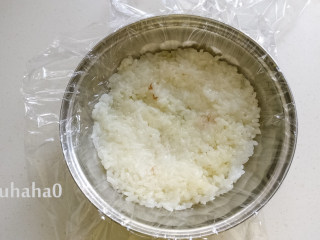 糯米红豆糕,用一个碗或其他喜欢的容器，在容器里铺一层保鲜膜，在碗底铺一层放凉的糯米饭，用手压实。