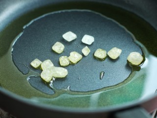 红烧肉炖土豆,锅中放食用油烧至五成热，加入冰糖小火翻炒至冰糖融化