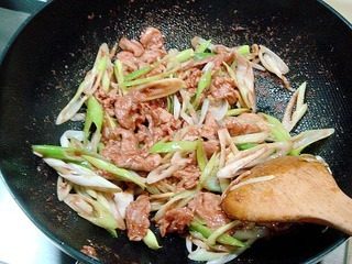 腐乳爆肉,然后烹入碗汁用旺火炒匀，炒匀后倒入葱丝。