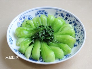 青菜炒火腿,将汆烫好的小油菜在盘中摆成一个圆形。小油菜茎部在外圈，叶子在内圈。