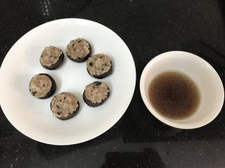 冬菇酿肉丸,蒸好后拿出来，把汁水倒入一小碗里