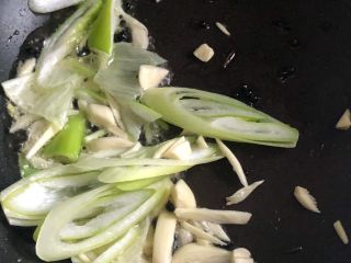 清炒茼蒿,倒入葱蒜