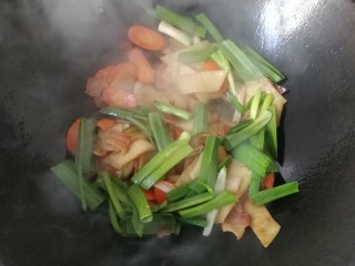 腊肉炒土豆饼,接着下入蒜青翻炒均匀；